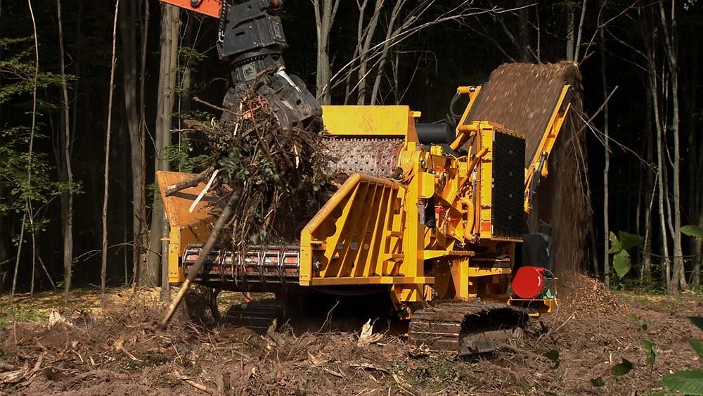 黄色伐木破碎设备在森林中作业